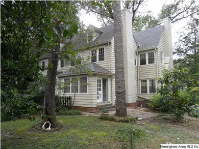 Rear view, many mature hardwood trees create a rur