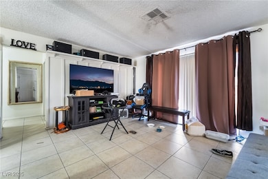 Living area featuring a textured ceiling and light tile patterned floors