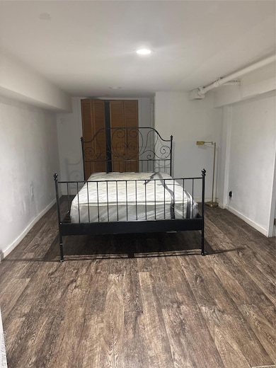 Bedroom featuring baseboards and dark wood-style floors