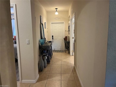 Hall with baseboards, visible vents, a textured wa