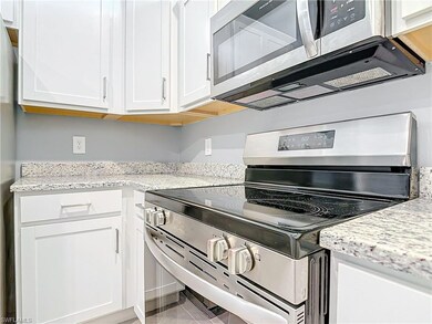Kitchen featuring white cabinetry, appliances with
