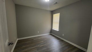 Unfurnished room featuring a textured ceiling and dark wood finished floors
