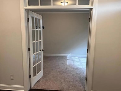 Corridor with baseboards and light carpet