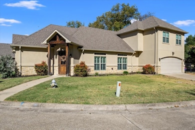 View of front of house featuring a front lawn, stone siding, stucco siding, an attached garage, and concrete driveway