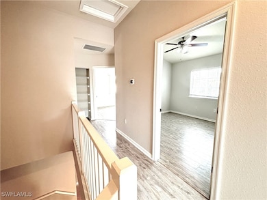 Hallway with an upstairs landing, visible vents, b