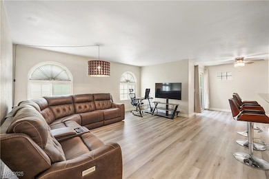 Living area with light wood-type flooring and ceiling fan