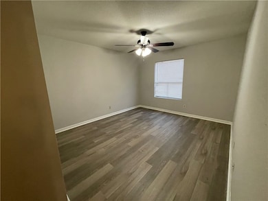 Empty room featuring ceiling fan and dark wood-typ