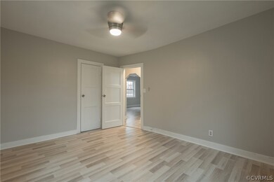 Empty room with ceiling fan and light wood-type fl