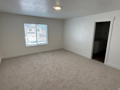 Unfurnished bedroom featuring light colored carpet, a textured ceiling, and ensuite bath