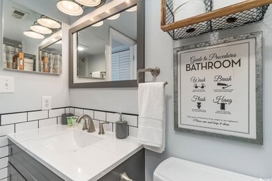 Bathroom with vanity, visible vents, backsplash, and toilet