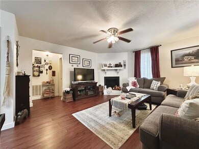 Unit 227 features laminate wood floors in living space, a wood burning fireplace, and neutral colored walls.