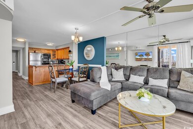 Living area featuring a chandelier, ceiling fan, light wood finished floors, and baseboards
