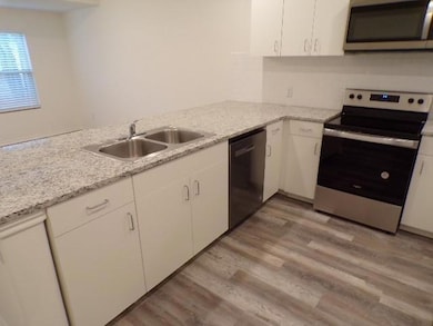 Kitchen featuring white cabinets, light wood-style