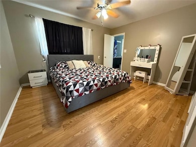 Bedroom with light wood-style floors and a ceiling fan