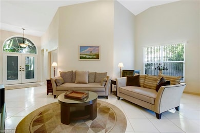 Living area featuring high vaulted ceiling, tile f