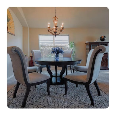 Carpeted dining space featuring a chandelier