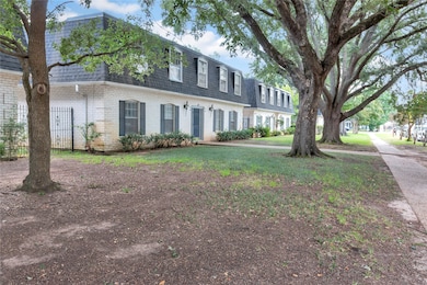 View of front of house with roof with shingles, mansard roof, brick siding, and a front yard