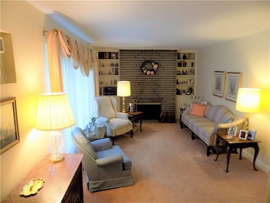 Living room features stone fireplace and built-in 