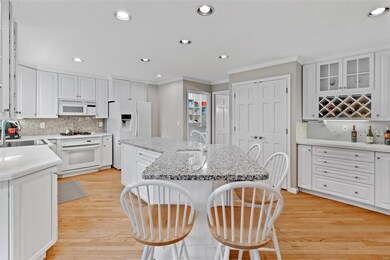Crisp, white kitchen has beautiful granite counter
