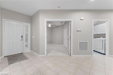 Entrance foyer with washing machine and dryer, a ceiling fan, and light tile patterned flooring