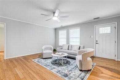 Living room with light hardwood / wood-style flooring, ornamental molding, and ceiling fan