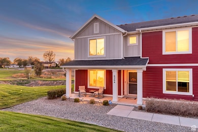 View of front of house with board and batten siding, covered porch, roof with shingles, and a lawn