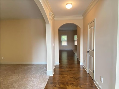 Corridor featuring arched walkways, crown molding,