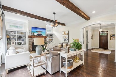 Living room with a barn door, crown molding, beam 