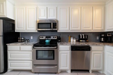 Kitchen with white cabinetry, light tile patterned