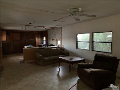 Living room featuring ceiling fan and wooden walls