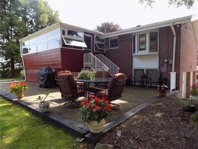 Spacious brick patio shaded by a mature tree.  Gre