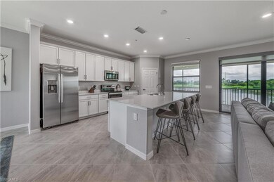 Kitchen featuring appliances with stainless steel finishes, sink, a breakfast bar area, white cabinets, and a center island with sink