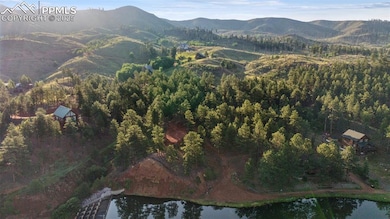Aerial overview of property's location with a water and mountain view and a heavily wooded area