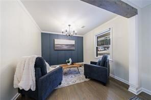 Sitting room with wood finished floors, a chandelier, and ornamental molding