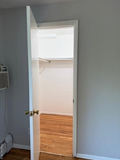 Closet with a baseboard radiator and a wall mounted AC