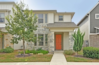 View of front of property with stone siding and roof with shingles