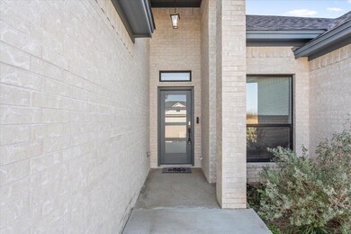 Doorway to property with brick siding and roof wi