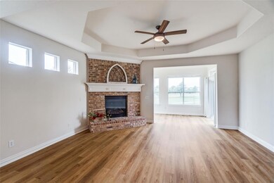 Living room with a raised ceiling, light hardwood 