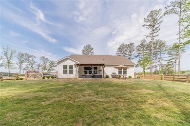 Back of house featuring fence, a lawn, and a patio