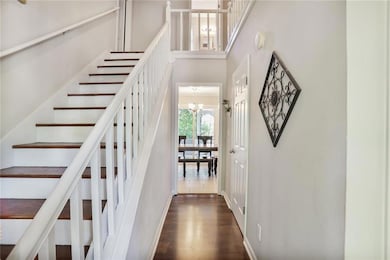Staircase featuring a chandelier, wood finished fl