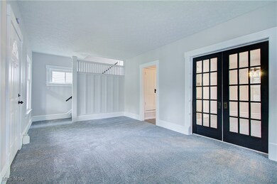 Unfurnished room with french doors, carpet floors, a textured ceiling, and baseboards