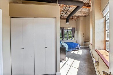 Carpeted bedroom featuring beamed ceiling and a cl