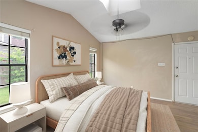 Bedroom with wood finished floors, lofted ceiling