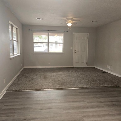1015 Unfurnished room featuring ceiling fan, baseboards, wood finished floors, and a textured ceiling