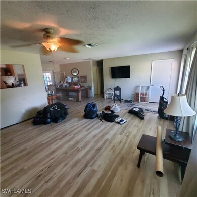 Living room featuring a textured ceiling, light ha