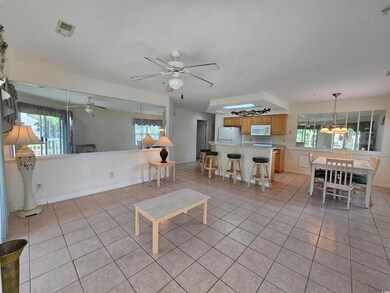 Living area with ceiling fan and light tile patterned flooring