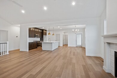 Unfurnished living room featuring recessed lighting, light wood finished floors, a fireplace, and a chandelier