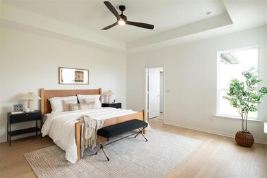 Bedroom featuring light wood-style flooring, a tr