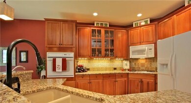 Kitchen includes cherry cabinets, new gas cook top, custom back splash with granite counter top.