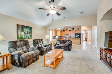Living room with light carpet, vaulted ceiling, an